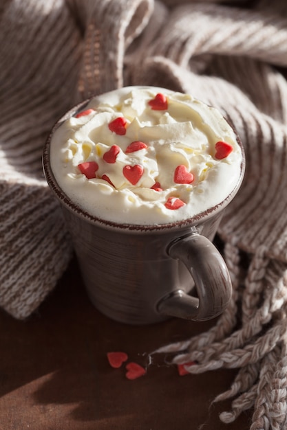 Tasse Kaffee mit Schlagsahne und roten Herzen