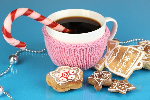 Tasse Kaffee mit Weihnachtssüße auf blauem Hintergrund