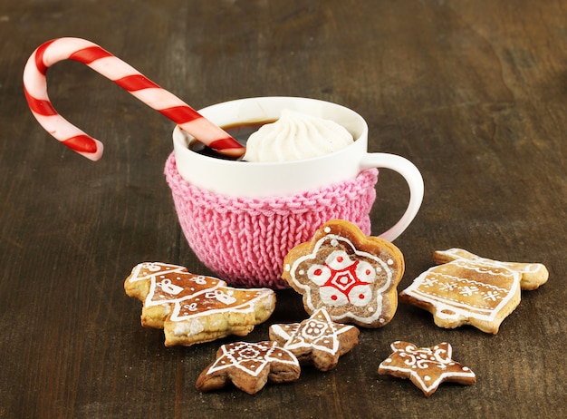 Tasse Kaffee mit Weihnachtssüße auf Holztisch Nahaufnahme