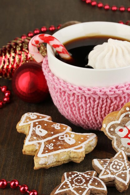 Tasse Kaffee mit Weihnachtssüße auf Holztisch Nahaufnahme