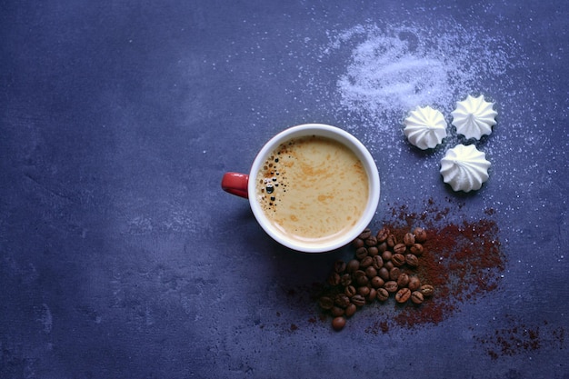 Tasse Kaffee mit Zephyr auf dunkelblauem Tisch