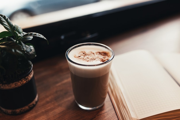 Tasse Kaffee, Notizbuch am Tisch im Café