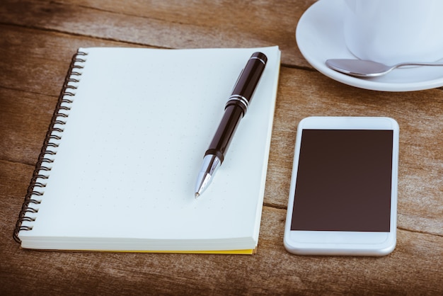 Tasse Kaffee, Notizbuch, Stift und intelligentes Telefon