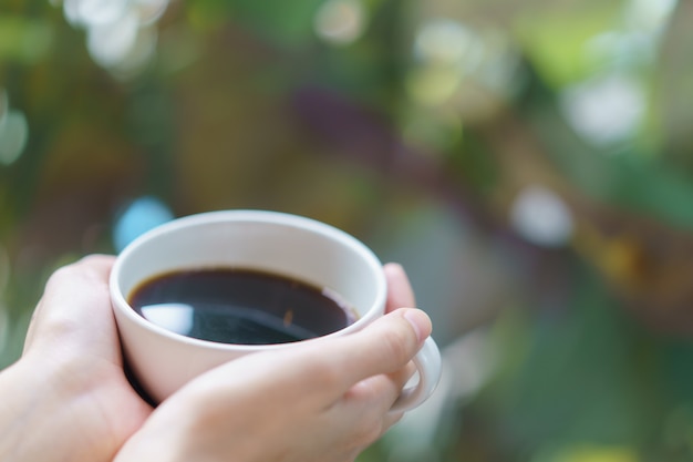 Tasse Kaffee oder Tee. Weiße Tasse heißes Getränk im Garten.