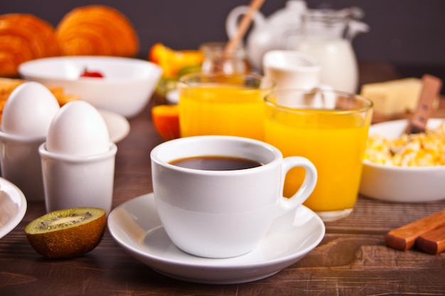 Tasse Kaffee, Saft, Eier, Obst, Toast. Frühstückskonzept.