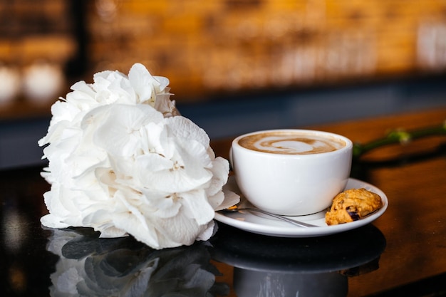 Tasse Kaffee und Blumen im Restaurant oder Café