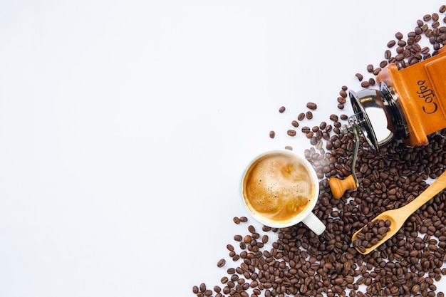 Tasse Kaffee und Bohne auf weißem Tischhintergrund. Draufsicht