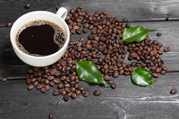 Tasse Kaffee und Bohnen auf Holzoberfläche