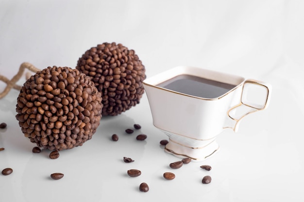 Tasse Kaffee und Bohnen auf weißem Hintergrund, Kaffeebohnen