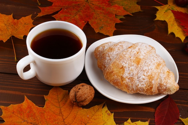 Tasse Kaffee und Croissant Herbststillleben