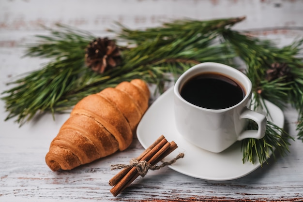 Tasse Kaffee und ein Hörnchen im Dekor des neuen Jahres.