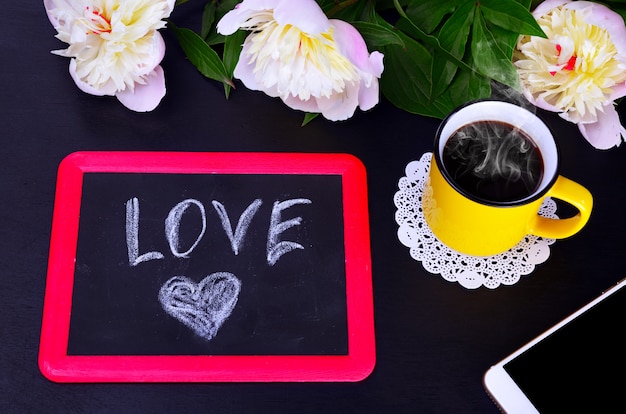 Tasse Kaffee und eine schwarze Kreidetafel mit Liebe