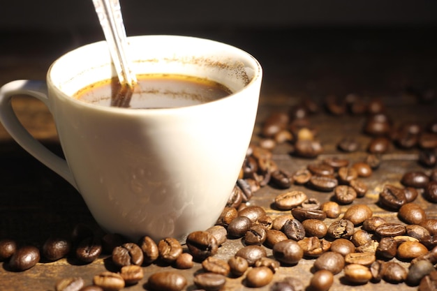 Tasse Kaffee und geröstete Kaffeebohnen auf dem Holztisch