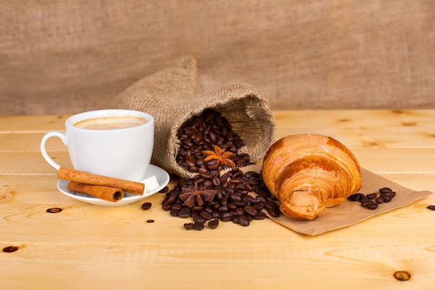 Tasse Kaffee und Kaffeebohnen auf einer Holzoberfläche