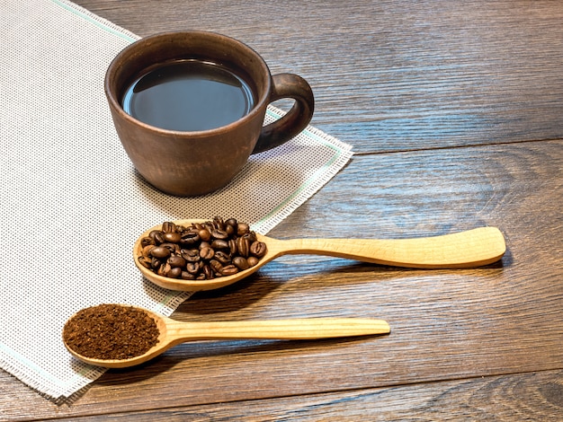 Tasse Kaffee und Kaffeebohnen in Holzlöffeln