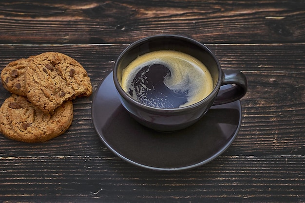 Tasse Kaffee und Kekse auf rustikalem Holztisch