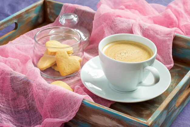 Tasse Kaffee und Kekse in Herzform auf Tablett. Konzept des Valentinstagsfrühstücks.