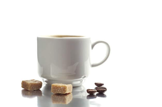 Tasse Kaffee und Kekse mit Reflexion auf weißem Hintergrund. Selektiver Fokus.