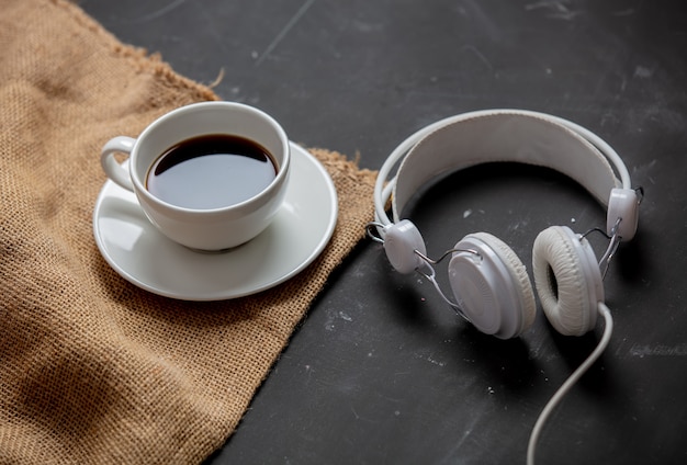 Tasse Kaffee und Kopfhörer auf einem Tisch