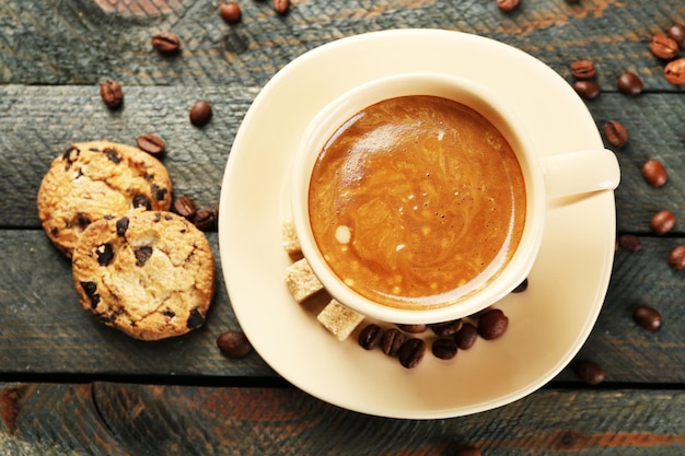 Tasse Kaffee und leckere Kekse auf Holzhintergrund