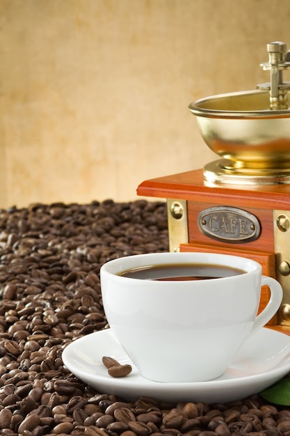 Tasse Kaffee und Mühle mit gerösteten Bohnen
