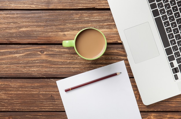 Tasse Kaffee und Papier mit Laptop-Computer