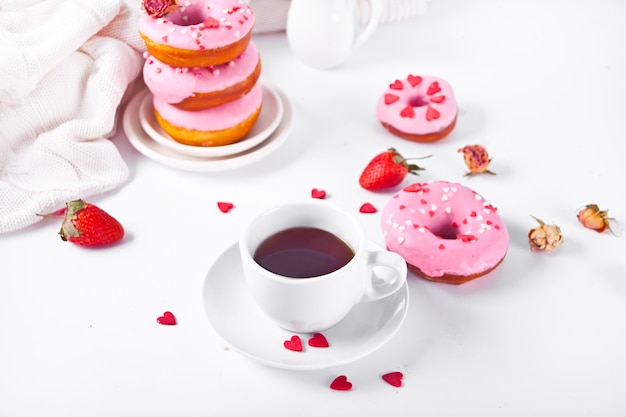 Tasse kaffee und rosa donuts