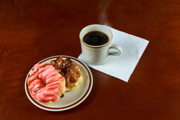 Tasse Kaffee- und Schokoladenkrapfen. Geschmackvolles Frühstück auf der hölzernen Tabelle.