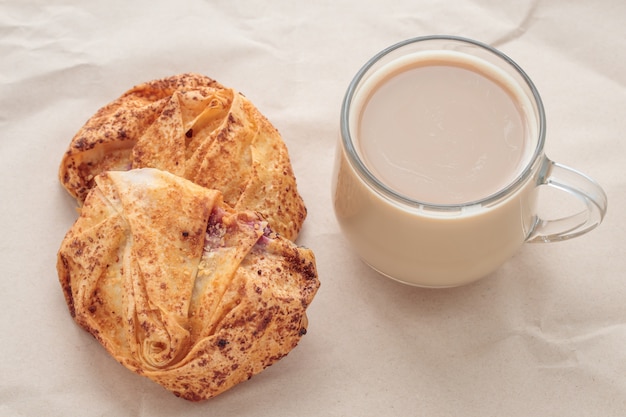 Tasse Kaffee und Scones auf braunem zerknittertem Papier