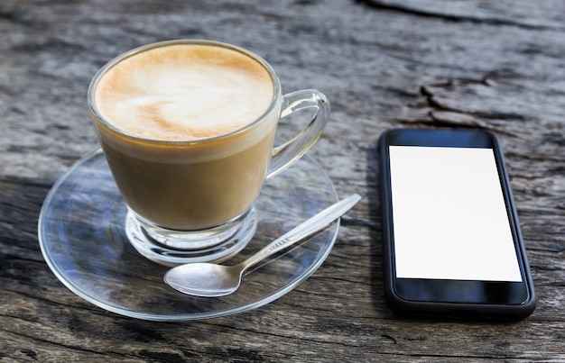 Tasse Kaffee und Smartphone auf Holztisch