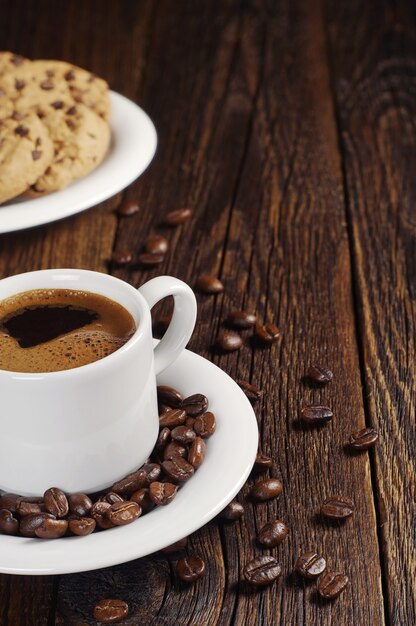Tasse Kaffee und süße Schokoladenkekse auf Vintage-Holztisch