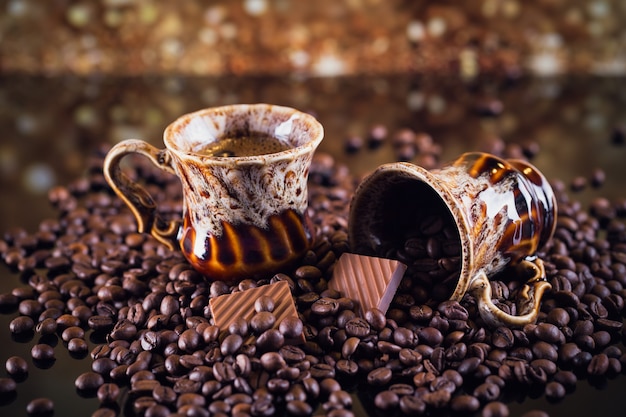 Tasse Kaffee und Tasse voller gerösteter Kaffeebohnen. Schöner Kaffeehintergrund.