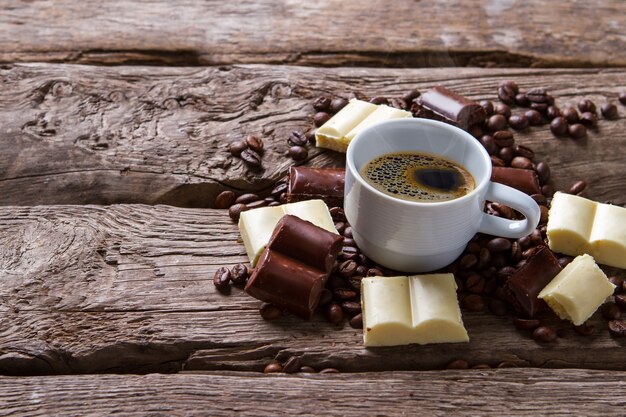 Tasse Kaffee. Weiße Schokolade und Kaffeebohnen. Leckeres Getränk ohne Zucker. Koffein und Kalorien.