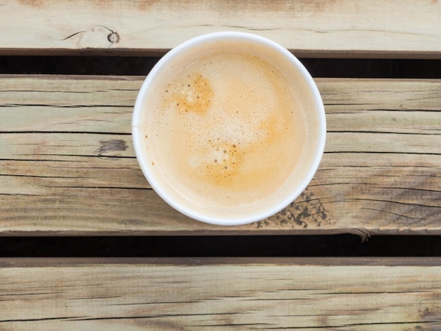 Tasse Kaffee zum Mitnehmen auf dem Holztisch Street Coffee Draufsicht