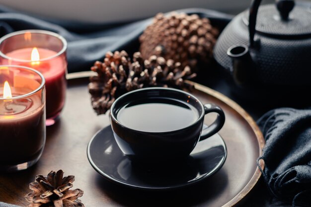 Foto tasse kaffeearomakerzen serviert in holztablett in gemütlichem wohninterieur einfache skandinavische wohnkultur nahaufnahme