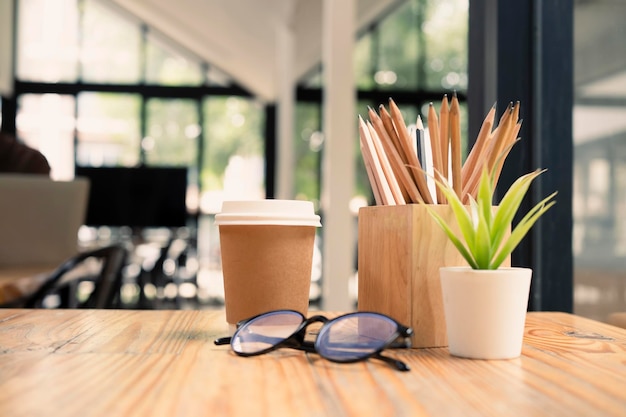 Tasse Kaffeegläser Pflanzenhaus und Bleistifthalter auf Holztisch