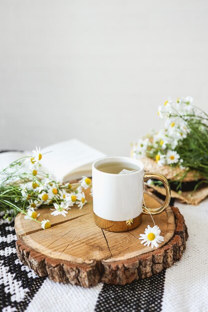 Tasse Kamillentee auf einem Holztablett