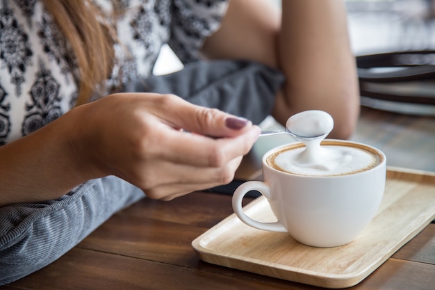 Tasse Kapuzinerkaffee mit Frau und Löffel