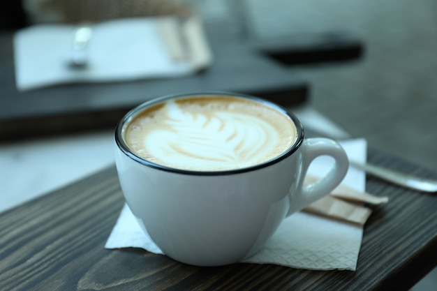 Tasse köstlichen Kaffee auf Holztisch im Freien im Restaurant