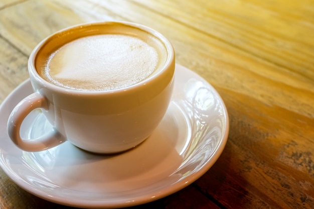 Foto tasse latte art kaffee mit warmem licht