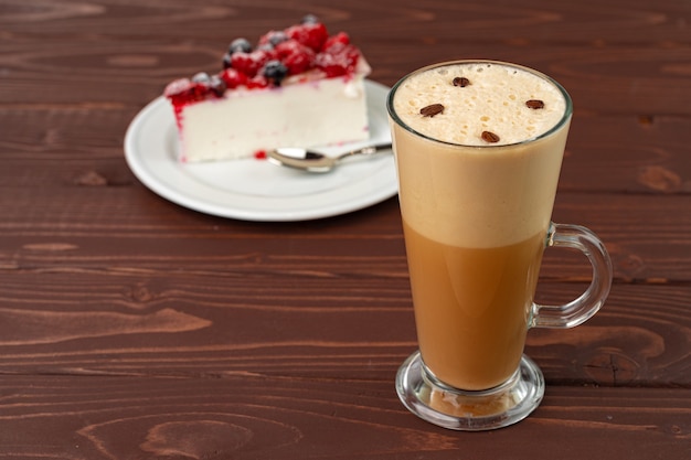 Tasse Lattekaffee mit Stück Beerenkäsekuchen hautnah