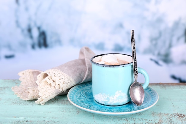 Tasse leckeren heißen Kakao, auf Holztisch, auf hellem Hintergrund