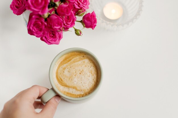 Tasse mit Kaffee und rosa Blumen