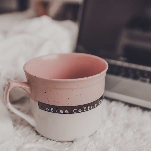 Tasse mit Laptop im Zimmer