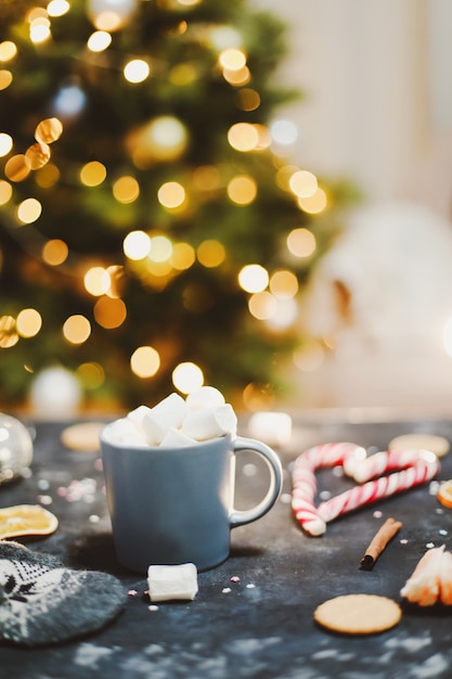 Tasse mit Marshmallows Zuckerstange Mandarinen von Weihnachtsbaum Hintergrund Neujahr Stillleben