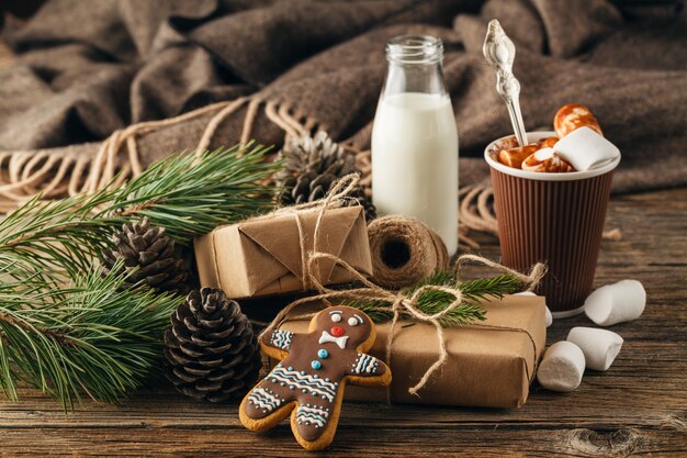 Tasse mit weihnachtlichem heißem Schokoladengetränk, Marshmallows und Zimt auf hellem Holztisch. Weihnachtsgeschenkkonzept,