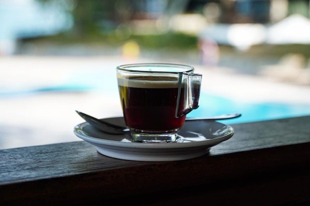 Tasse schwarzen heißen Kaffee Seaside Hintergrund klares Glas und Untertasse AmericanoMorning Kaffee Hintergrund Essen und Trinken