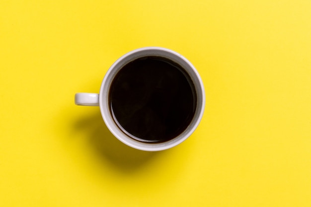 Tasse schwarzen Kaffee auf gelber Oberfläche