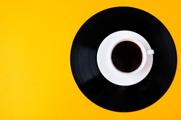 Tasse schwarzen Kaffee auf Vinylplatte. Platz kopieren. Musik hören. Retro-Stil. Podcast.