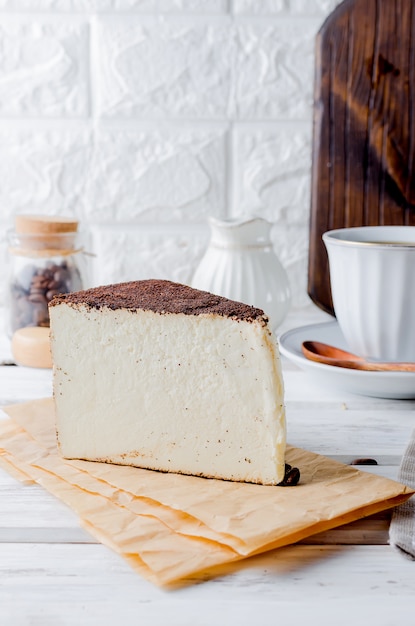 Tasse schwarzen Kaffee mit einem Stück Frischkäse